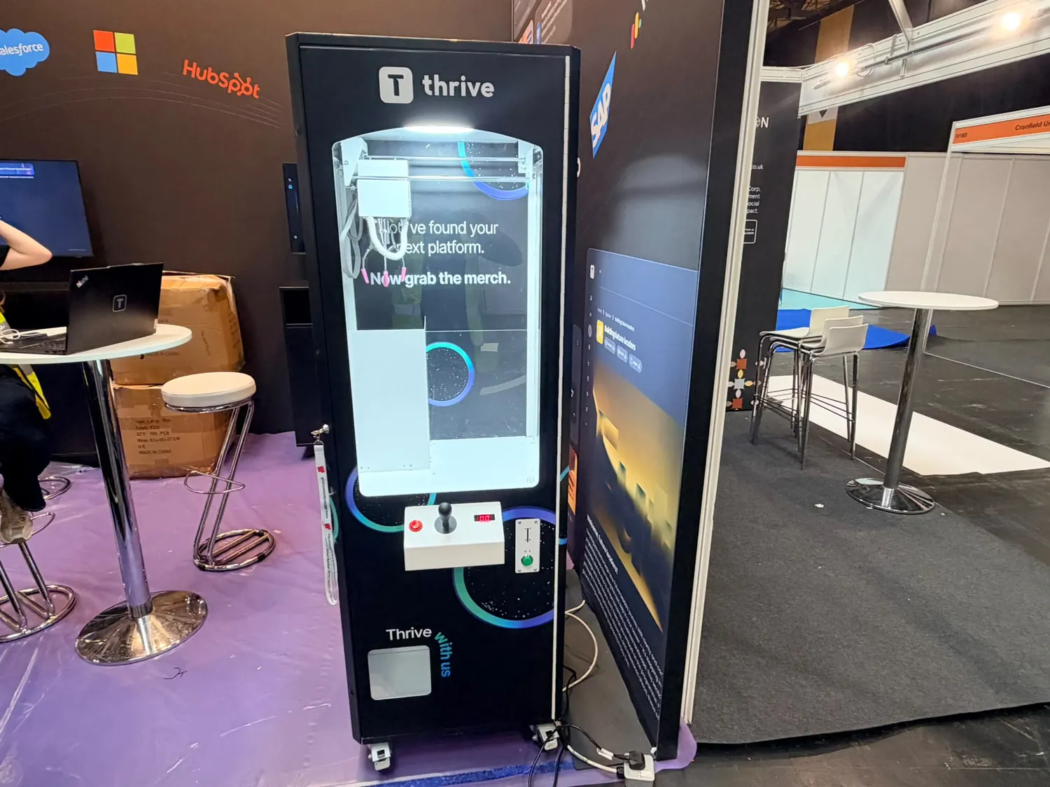 Branded claw machine lit up on an exhibition stand