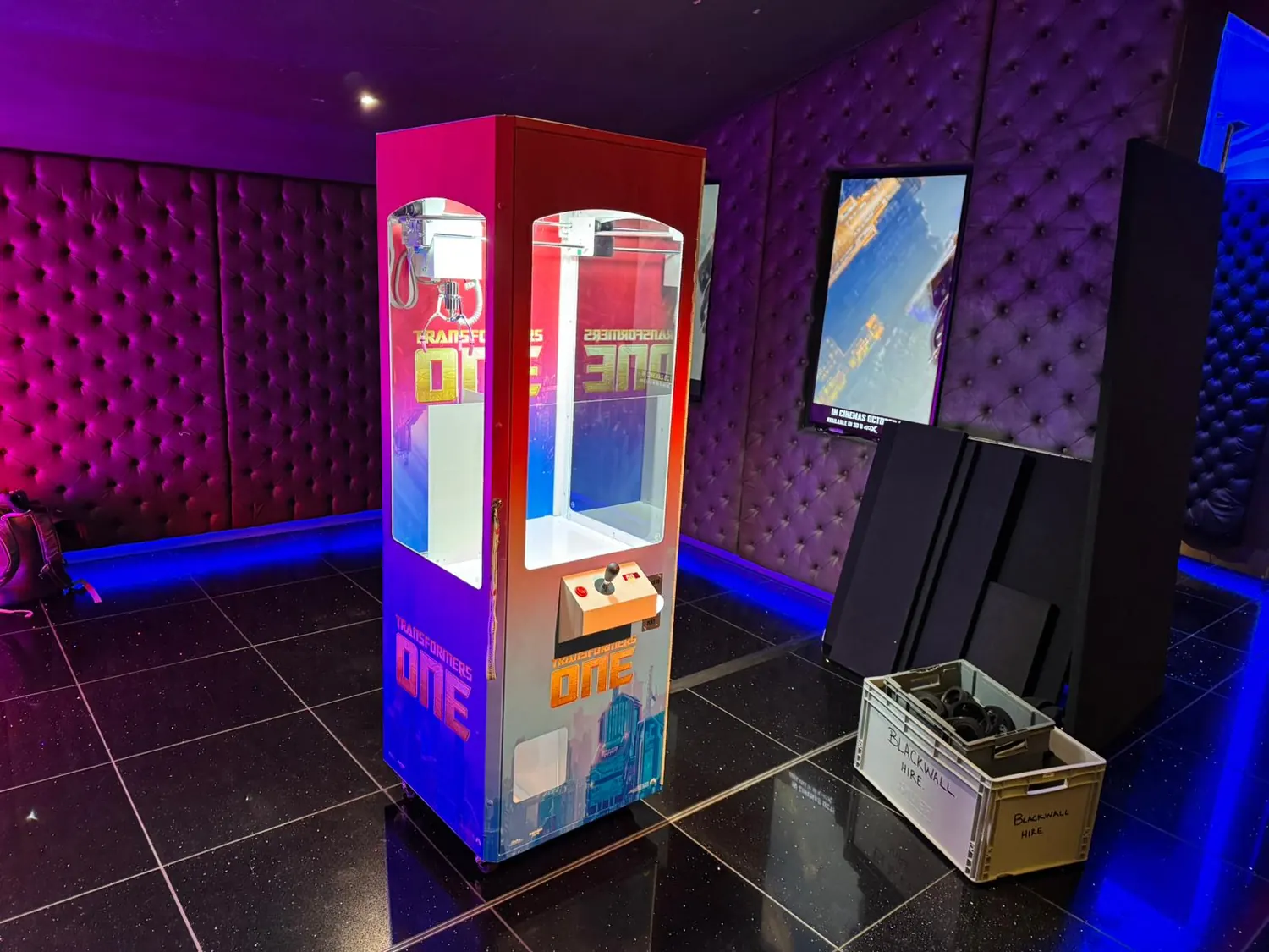 Claw machine hire at a party venue with neon lighting