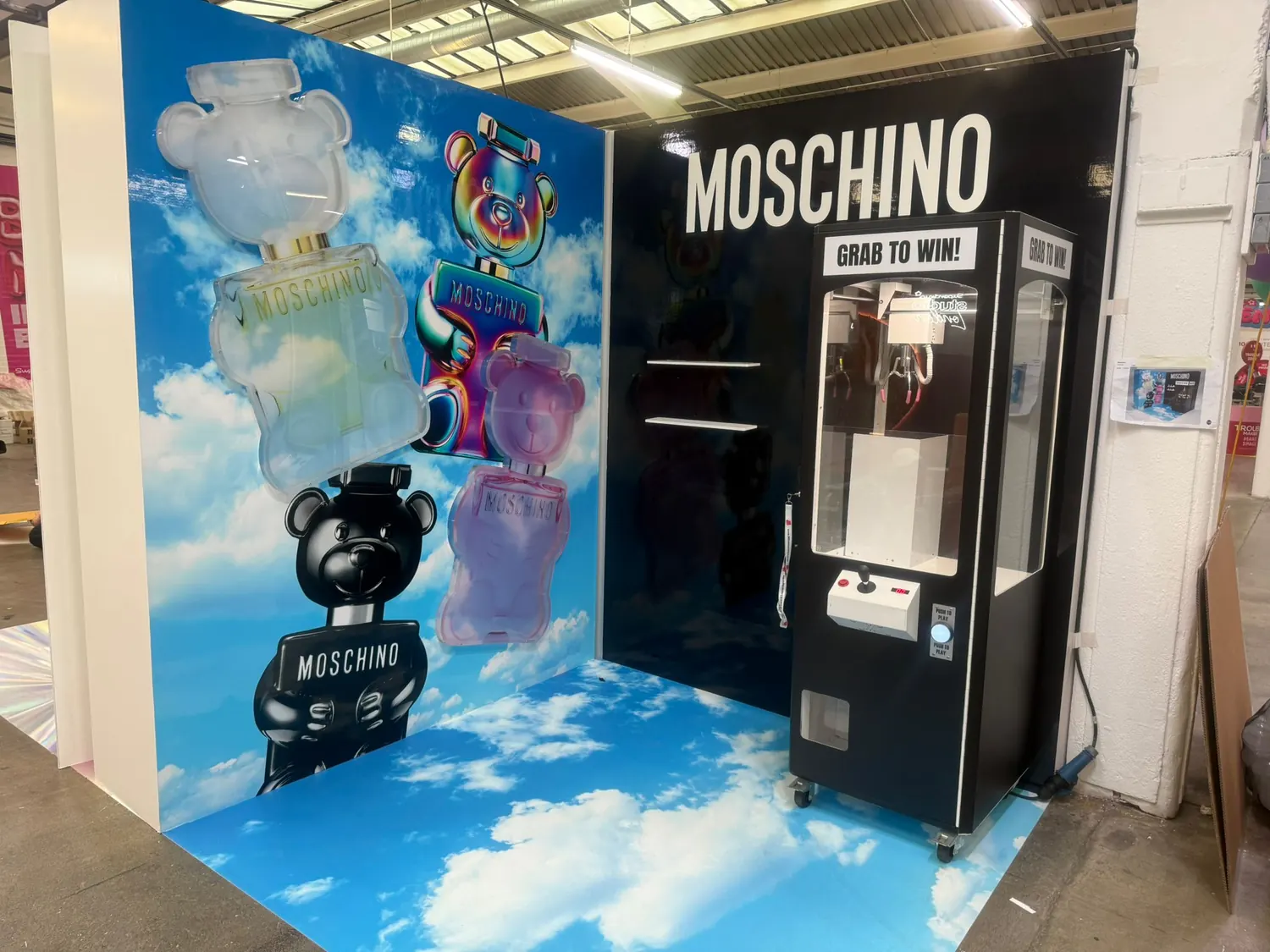 Luxury branded claw machine on a fragrance launch stand