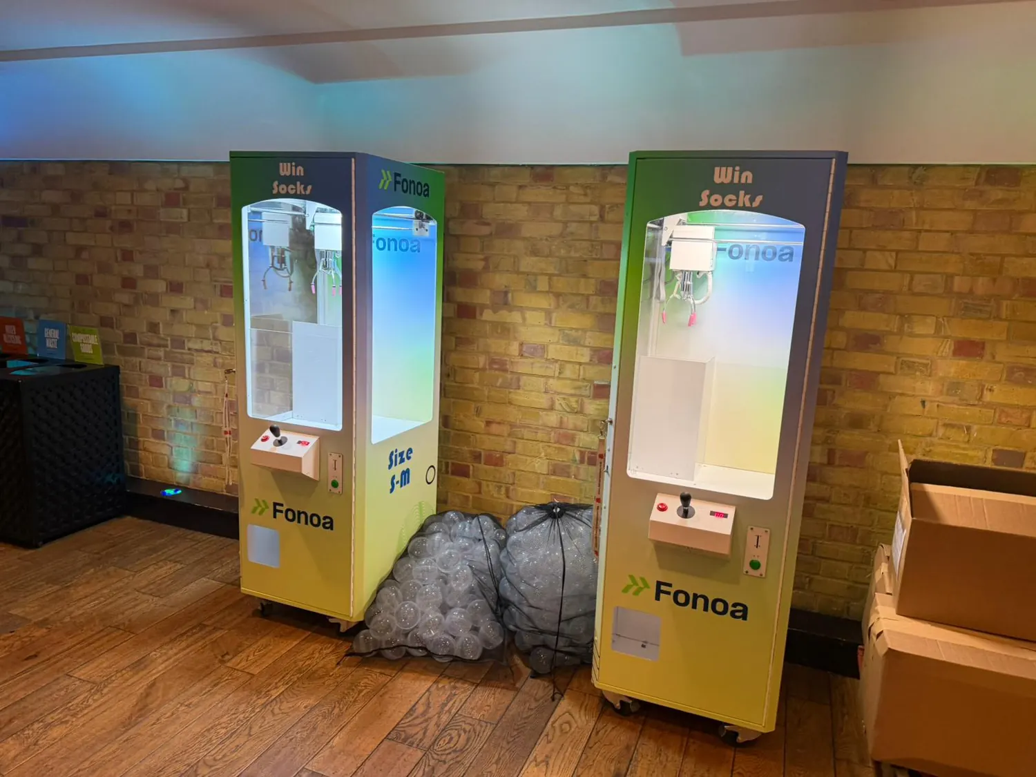 Two branded claw machines lit up at a corporate event